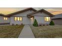 Inviting single-story home with manicured shrubs, a well-kept lawn, and warm lighting at 23 Carla Way, Broomfield, CO 80020