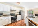 Bright kitchen with stainless steel appliances, white cabinets, and wood flooring at 5145 W 61St Dr # 14, Arvada, CO 80003