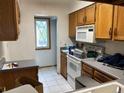 View of kitchen area with white appliances, tile floors and window view at 8181 S Fillmore Cir, Centennial, CO 80122
