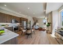 Bright living room with modern kitchen, dining area, wood floors, and stairs at 1372 Lowell Blvd # 1, Denver, CO 80204