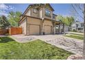 A view of a tan home highlighting a two-car garage and inviting front porch at 16376 Flintlock Ct, Parker, CO 80134