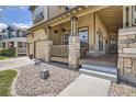 A view of a porch showcasing a cozy rocking chair and stone-covered columns at 16376 Flintlock Ct, Parker, CO 80134