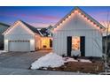 Two-story farmhouse with charming front entry and festive string lights at 14319 Hop Clover St, Parker, CO 80134