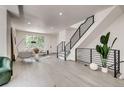 Spacious living room featuring modern black railing staircase and natural light, complemented by stylish decor and light wood flooring at 536 Cook St, Denver, CO 80206