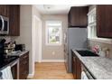 Efficient kitchen featuring dark wood cabinets, granite countertops, and stainless steel appliances at 1712 S Gilpin St, Denver, CO 80210