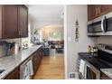 Open concept kitchen flowing into the living area, featuring stainless steel appliances and wood floors at 1712 S Gilpin St, Denver, CO 80210