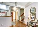 Open-concept foyer leads to stairs and living area with hardwood floors at 3820 S Ames St, Denver, CO 80235