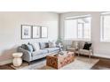 Spacious living room featuring hardwood floors, modern furnishings, and natural light from the large window at 11488 E 25Th Dr, Aurora, CO 80010