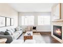 Bright and airy living room features a decorative fireplace, dark hardwood floors, and an open floor plan at 11488 E 25Th Dr, Aurora, CO 80010