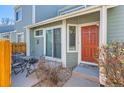 Inviting entryway with a bright red door, decorative glass window, and a cozy outdoor seating area at 5128 Buckingham Rd, Boulder, CO 80301