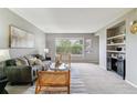 Bright living room with a large window, comfortable seating, and built-in shelving at 9283 E Arbor Cir # C, Englewood, CO 80111