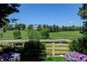 Picturesque backyard view with a tranquil pond, lush greenery, and a charming wooden fence at 2937 W Yarrow Cir, Superior, CO 80027