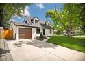 Inviting home featuring a well-maintained lawn, modern garage door, and classic architectural details at 1980 S Kearney Way, Denver, CO 80224
