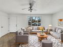 Bright, virtually staged living room featuring neutral tones, a ceiling fan, and a large window at 3118 S Joplin Ct, Aurora, CO 80013