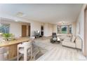 Bright living space with wood-look floors, neutral decor, and abundant natural light from the large windows at 3840 Sierra Vista Rd, Monument, CO 80132
