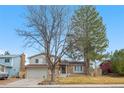 Two-story home with brick accents, attached garage, and mature trees, offering great curb appeal at 3930 S Argonne Way, Aurora, CO 80013