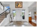 Bright foyer with high ceilings, a staircase, and tiled floors creating a welcoming atmosphere for guests at 5319 W Hoover Dr, Littleton, CO 80123
