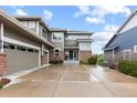 A beautifully designed house with a spacious driveway, neutral siding, and a welcoming entrance exudes curb appeal at 5319 W Hoover Dr, Littleton, CO 80123