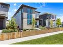 Contemporary home featuring a gated front yard, modern design and a combination of stone and siding under a blue sky at 21405 E 59Th Dr, Aurora, CO 80019