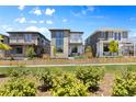 Modern home with landscaped yard, gated fence and exterior balcony in a neighborhood setting under a blue sky at 21405 E 59Th Dr, Aurora, CO 80019