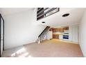 Inviting living room with stairs, neutral carpet, white walls, and open access to a kitchen at 381 S Estes St # 1, Lakewood, CO 80226