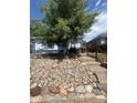 Exterior view of a house with attractive stone landscaping and a mature shade tree at 3306 S Logan St, Englewood, CO 80113