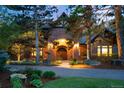 Elegant brick home featuring a grand arched entrance and lush landscaping at 1328 E Layton Ave, Cherry Hills Village, CO 80113