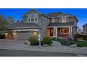 Beautiful two-story home with stone accents, a covered porch, a two-car garage, and a walkway leading to the front door at 9375 S Hoyt Ct, Littleton, CO 80127