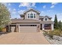 Inviting two-story home features a two-car garage, a covered porch, and a well-maintained yard with mature trees at 9375 S Hoyt Ct, Littleton, CO 80127