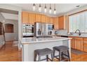Bright kitchen features wood cabinets, stainless steel appliances, a center island, and a window for natural light at 9375 S Hoyt Ct, Littleton, CO 80127