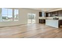 Open concept living space with large windows, hardwood floors, and sliding glass doors leading to the backyard at 174 Baler Ct, Brighton, CO 80601