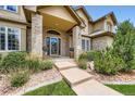 Inviting home entrance with brick facade, stylish door, and manicured landscaping along the pathway at 3400 Elk Run Dr, Castle Rock, CO 80109