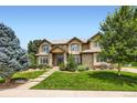 Beautifully landscaped front yard of a home with lush green grass, mature trees, and a stone pathway at 3400 Elk Run Dr, Castle Rock, CO 80109