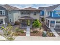 A charming two-story home features a covered porch, modern design, and neatly landscaped front yard at 21482 E 60Th Ave, Aurora, CO 80019