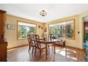 Comfortable dining room with hardwood floors and large windows overlooking a beautiful yard at 2397 Hearth Dr, Evergreen, CO 80439