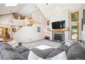 Inviting living room featuring a fireplace, high ceilings, and plenty of natural light at 2397 Hearth Dr, Evergreen, CO 80439
