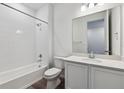 Clean bathroom with white tile surround, shower/tub combo, and modern vanity at 19100 E 96Th Pl, Commerce City, CO 80022