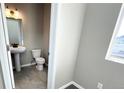 Compact half bath features a pedestal sink, toilet, and stylish tile flooring at 16830 Mckay Dr, Mead, CO 80542