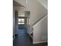 Spacious hallway with gray walls and hardwood floors leading to the stairs at 16830 Mckay Dr, Mead, CO 80542