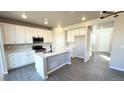 Modern kitchen features white cabinets, gray island, stainless appliances, and wood floors at 16830 Mckay Dr, Mead, CO 80542