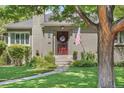 Charming home featuring a well-manicured lawn, stone walkway, and inviting front porch with an American flag at 675 Dahlia St, Denver, CO 80220