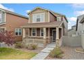 Charming two-story home featuring a cozy front porch and well-maintained landscaping at 15842 E Warner Dr, Denver, CO 80239