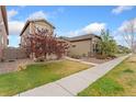 Beautiful home with a well-kept lawn, landscaping, and a sidewalk leading to the front at 15842 E Warner Dr, Denver, CO 80239