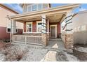 Covered porch with stone pillars and festive lights at 15842 E Warner Dr, Denver, CO 80239