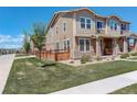 Well-maintained townhouse with a lush lawn, fenced yard, and sidewalk access at 4316 S Netherland St, Aurora, CO 80015