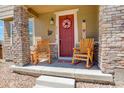 Inviting front porch with stone pillars, rocking chairs, and charming decor at 4316 S Netherland St, Aurora, CO 80015