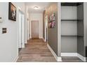 Hallway features wood-look floors, neutral walls, shelving, and multiple doors leading to other rooms at 5677 S Park Pl # A102, Englewood, CO 80111