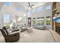 Bright living room with high ceilings, many windows, and a cozy fireplace at 2373 S Joyce St, Denver, CO 80228