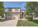 Two-story home featuring a brick and siding exterior, attached garage, and well-maintained lawn, exuding curb appeal at 16685 Trail Sky Cir, Parker, CO 80134