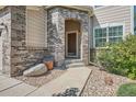 Welcoming front entrance with a brick archway, stone pathway, and landscaped surroundings, creating a warm invitation at 16685 Trail Sky Cir, Parker, CO 80134